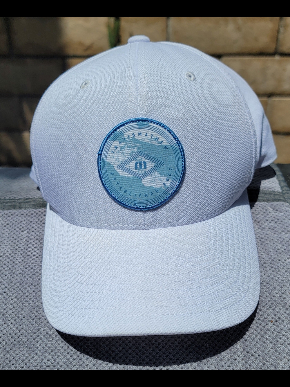 TravisMathew Golf Hat "Grab The Rail" Snapback in White with Blue Patch